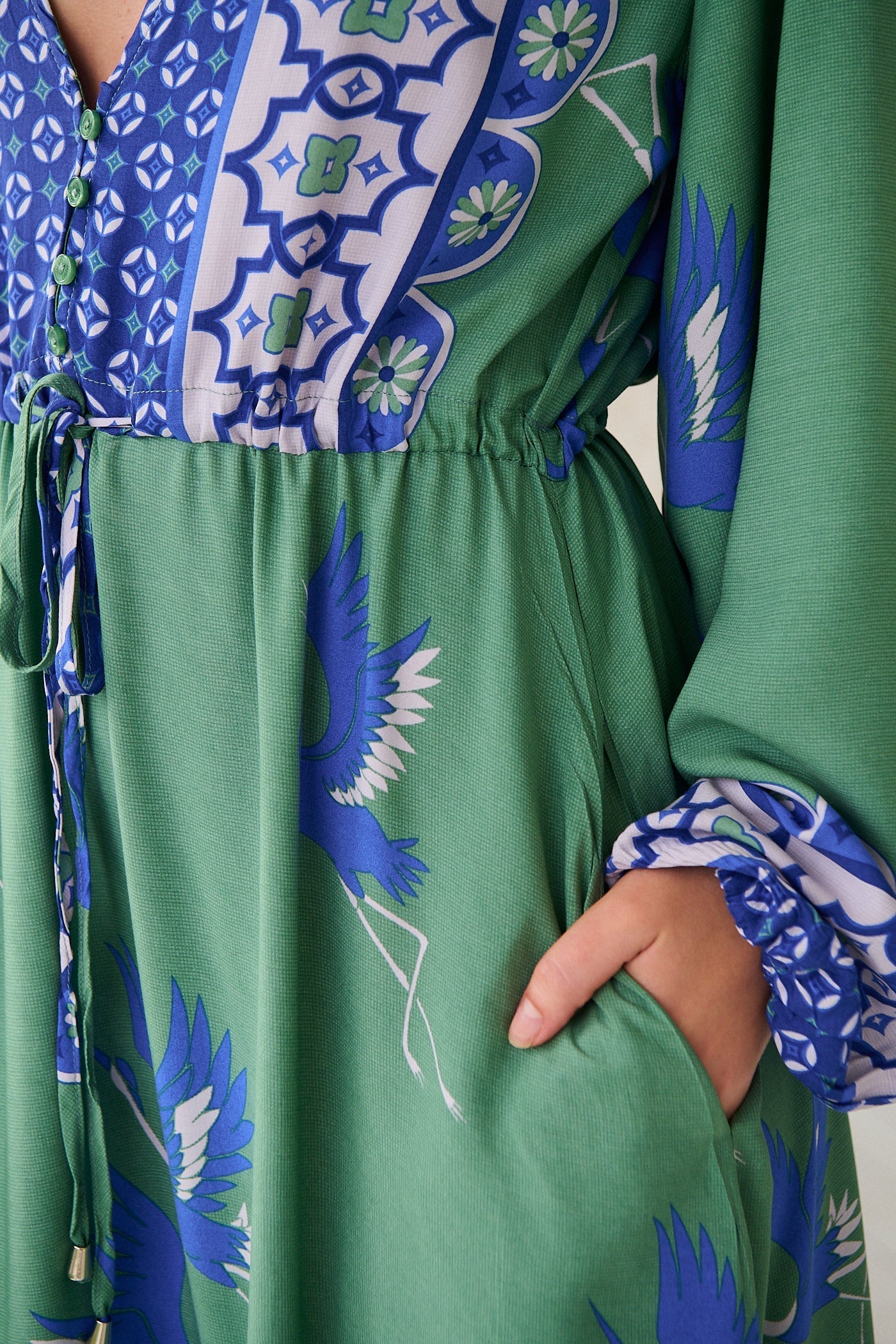 Close up of green JAASE boho dress with blue and white bird print and tie waist detail - Bohemian Love Runway.