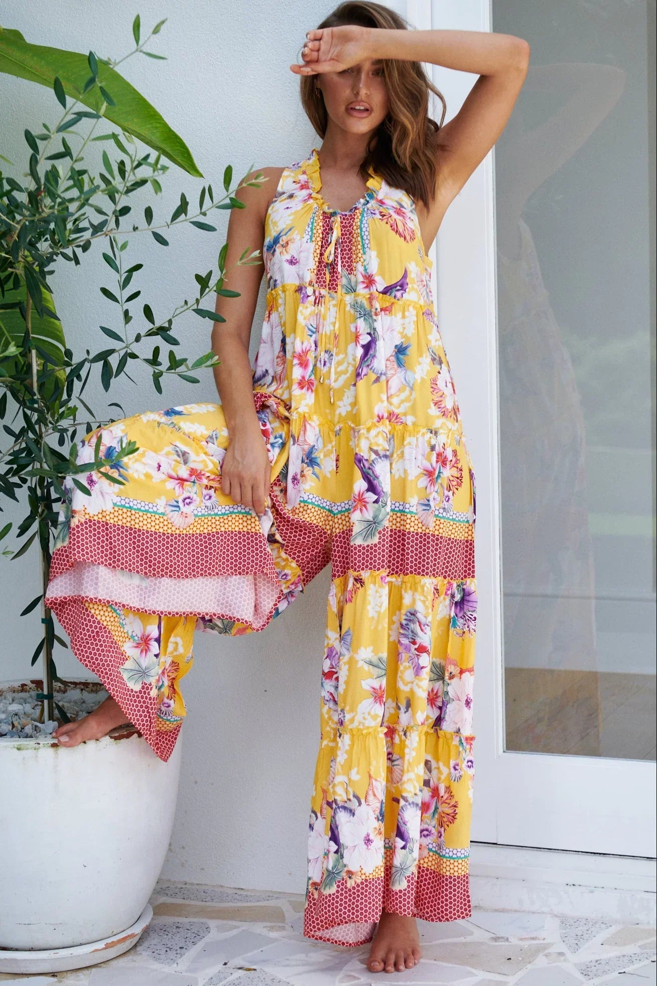 Woman in a bright boho floral set with pink and yellow wide-leg pants and matching top, standing indoors - Bohemian fashion Australia.