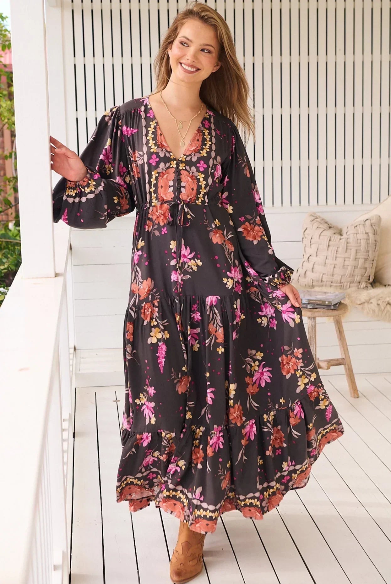 Model wearing a romantic bohemian maxi dress with gypsy-inspired floral print, tiered skirt, and soft ruffled sleeves in vintage-inspired prints.