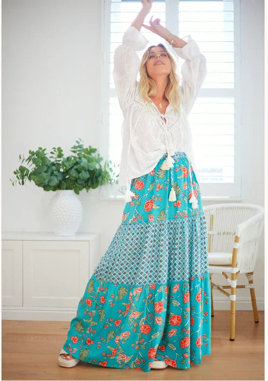 woman in a teal floral blouse maxi skirt with with blouse, dancing indoors - Australia boho skirts for maxi, midi and mini styling.
