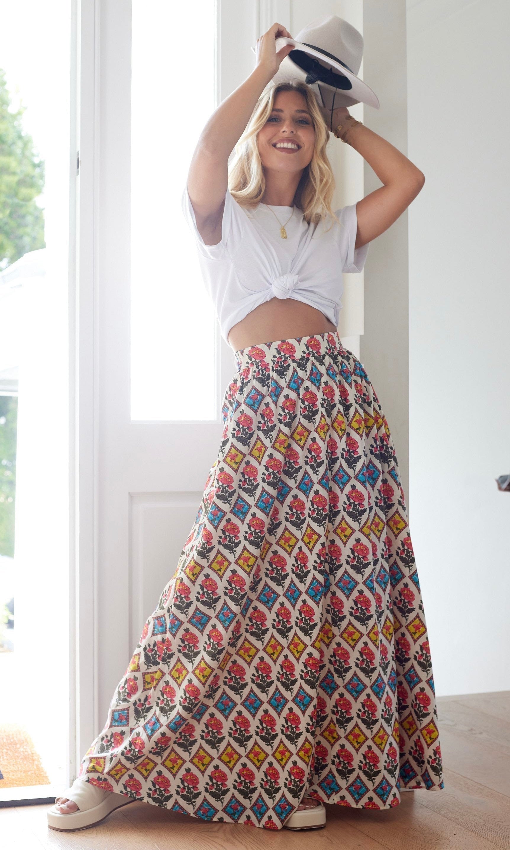 Model wearing the Calista Skirt in a soft floral print with tiered layers and a free-flowing silhouette, perfect for boho-chic styling for all seasons