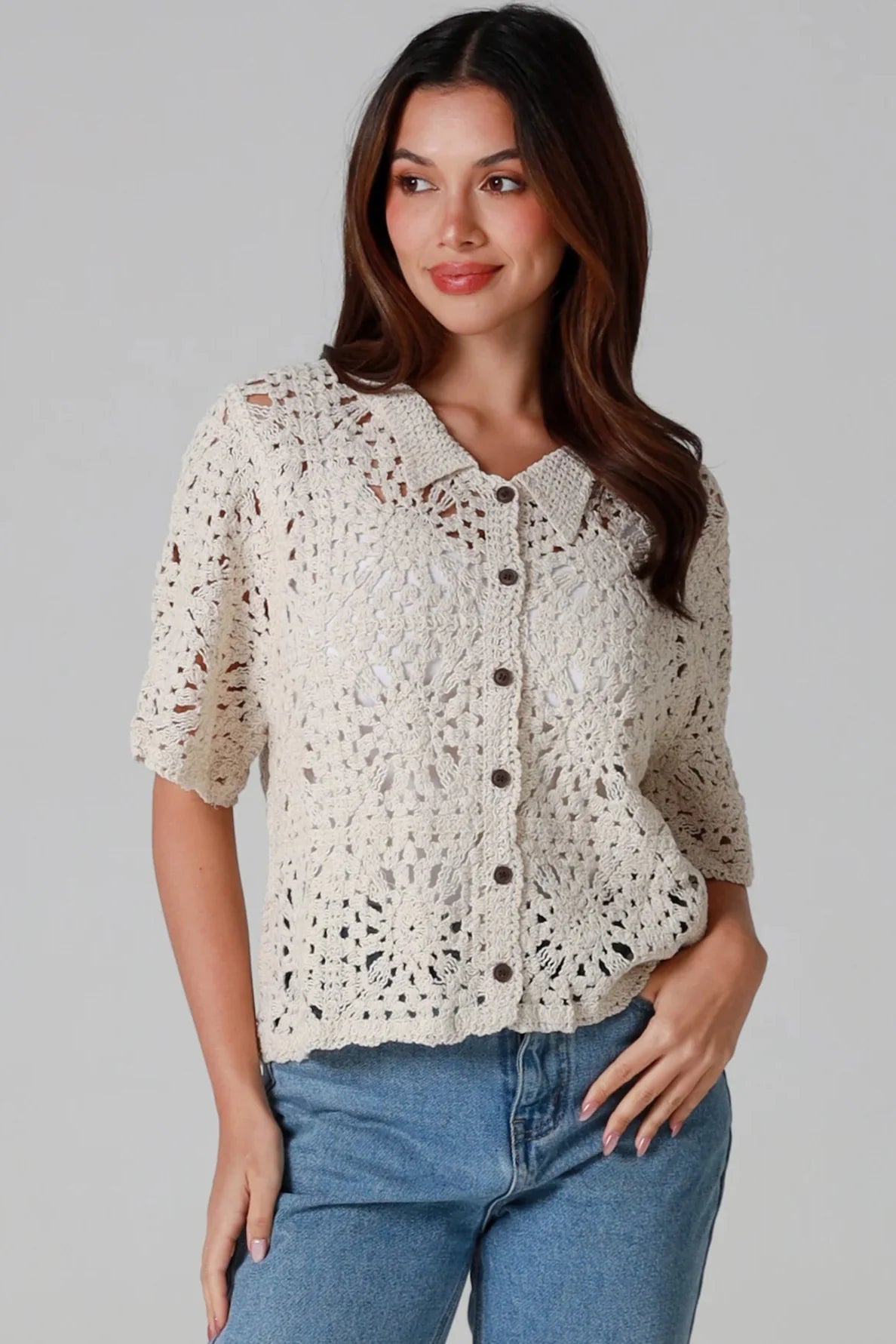 Boho woman in cream crochet button-up blouse with elbow sleeves and blue jeans _ Willow The Label crochet cotton lace top.