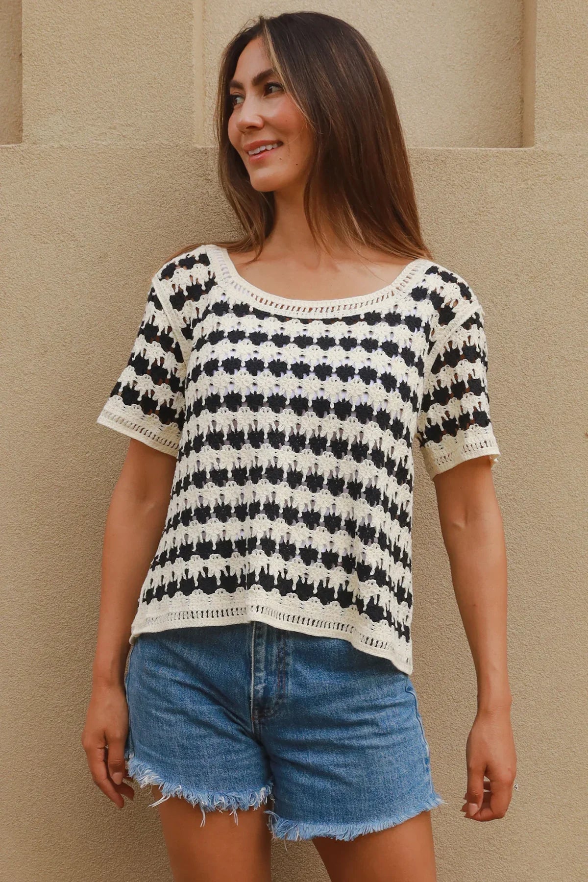 Woman in crochet top and denim shorts, styled by Bohemian Love Runway - Isabella The Label.