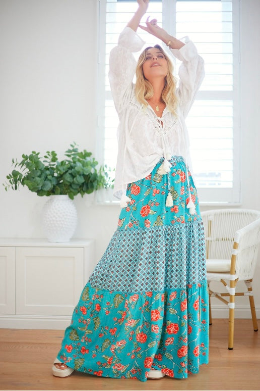 Model wearing a boho floral skirt with tiered layers and flowing silhouette, perfect for beach holidays and free spirited styling.