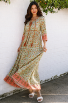 Lauren 100% cotton floral boho maxi dress in sage green with coral botanical print, tassel ties and contrast border hem