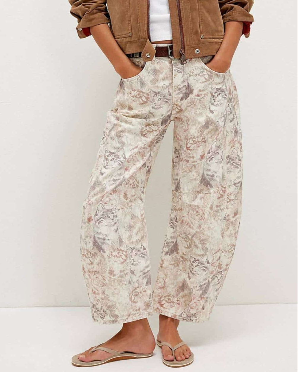 Woman wearing midi-rise artistic floral print barrel jeans in blush and taupe tones - relaxed boho cotton denim Australia.