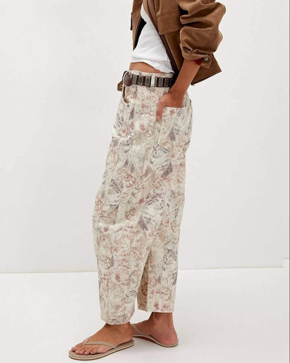 Woman wearing midi-rise artistic floral print barrel jeans in blush and taupe tones - relaxed boho cotton denim Australia.