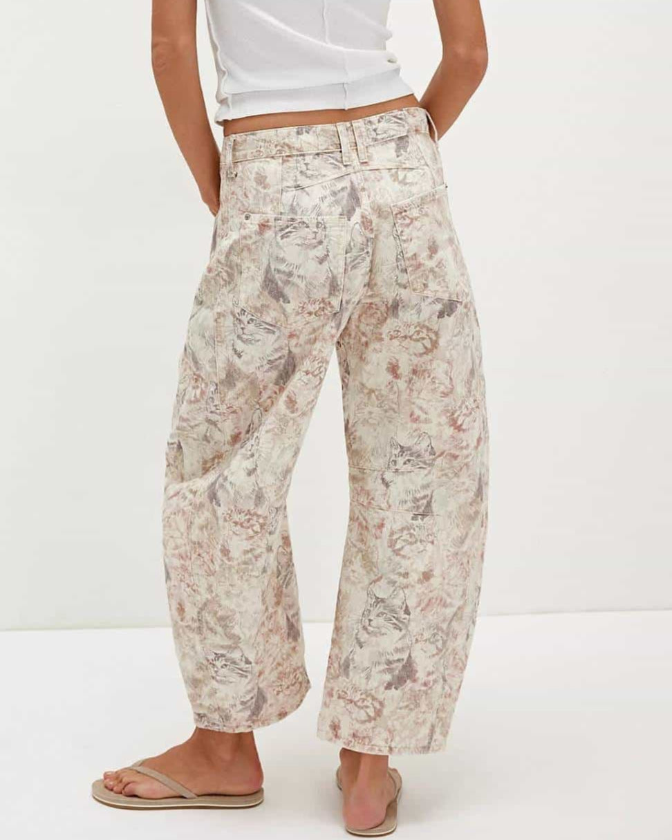 Woman wearing midi-rise artistic floral print barrel jeans in blush and taupe tones - relaxed boho cotton denim Australia.