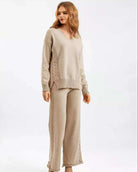 Woman wearing beige cotton cable knit lounge set with relaxed V-neck sweater and wide-leg pants - cozy boho loungewear Australia.