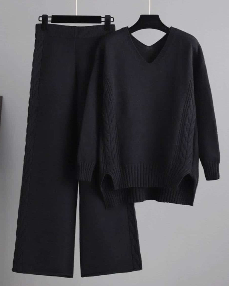 Woman wearing black cable knit lounge set with wide-leg pants and relaxed V-neck sweater —100% cotton winter knitwear.