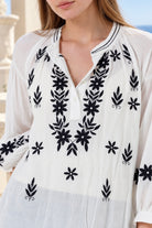 White Salty Palm cotton blouse with navy floral embroidery, V-neck button front, gathered long sleeves and stitched cuffs