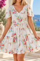 Salty Palm ivory floral boho mini dress in rayon with V-neck, flutter sleeves, drawstring waist and oversized frill hem