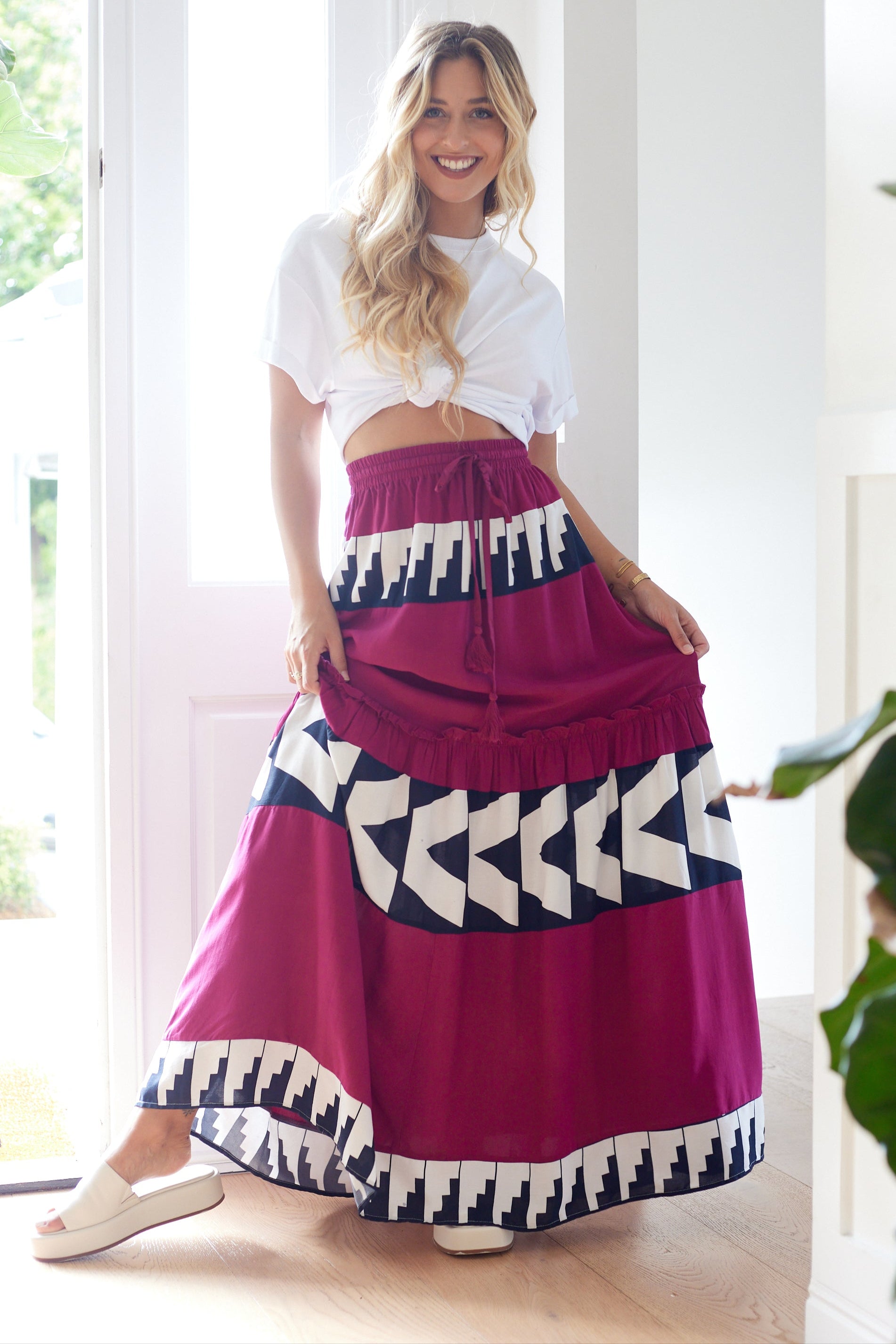 Woman wearing a colorful skirt with geometric patterns indoors.