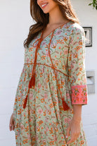 Lauren 100% cotton floral boho maxi dress in sage green with coral botanical print, tassel ties and contrast border hem