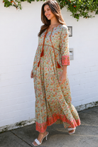 Lauren 100% cotton floral boho maxi dress in sage green with coral botanical print, tassel ties and contrast border hem