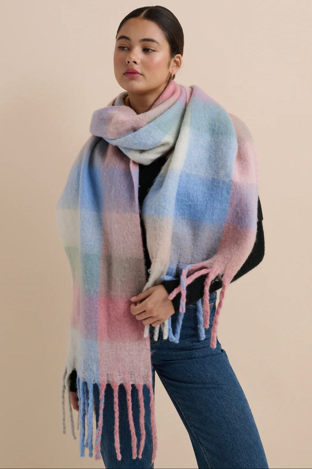 Woman in a pastel check boho winter scarf with blush, blue, and cream tones and long tassels - The Aurielle Scarf by Bohemian Love Runway 