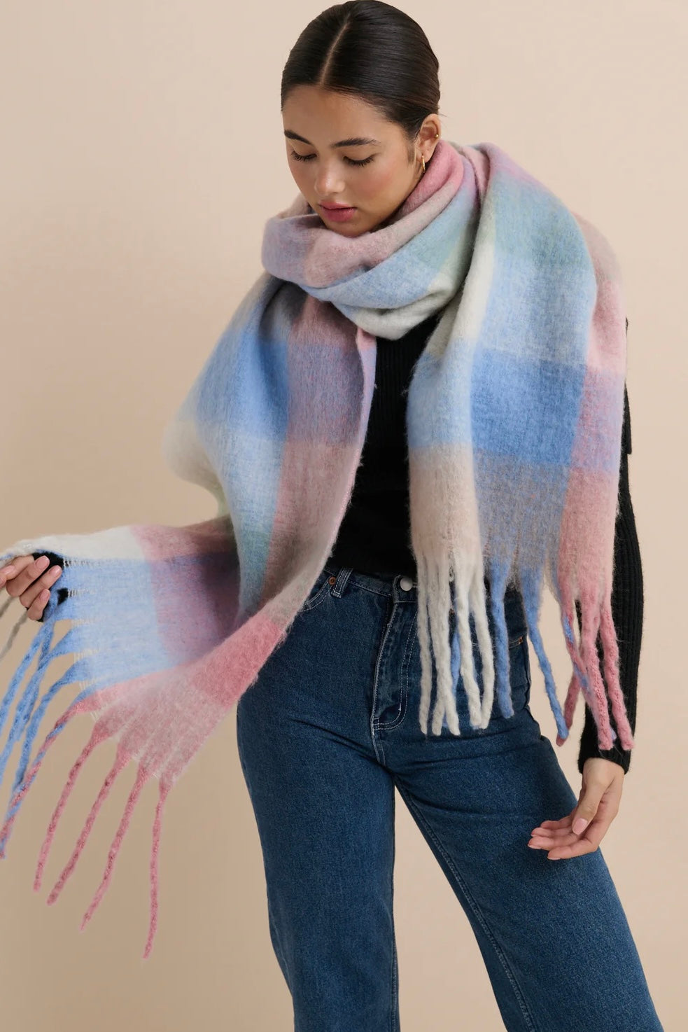 Woman in a pastel check boho winter scarf with blush, blue, and cream tones and long tassels - The Aurielle Scarf by Bohemian Love Runway 