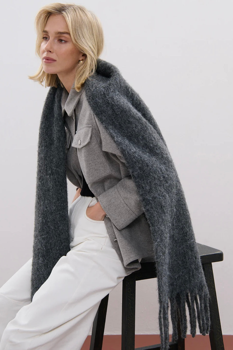 Woman wrapped in a charcoal fluffy boho wool blend scarf with fringe - The Midnight Hour winter wrap from Bohemian Love Runway.