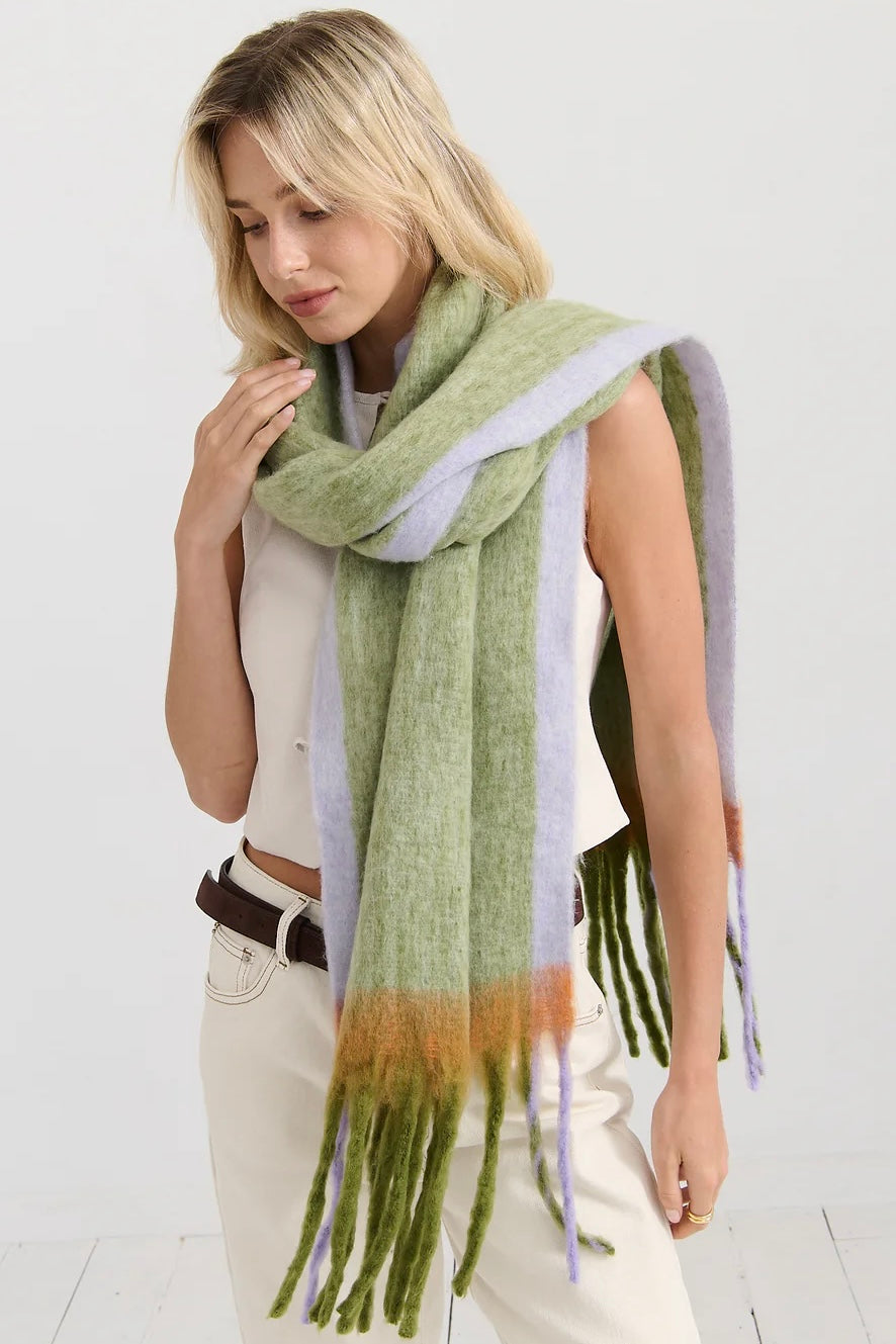 Woman in oversized green and lilac checkered scarf with fringe, wrapped in soft winter layers - Bohemian Love Runway scarf.