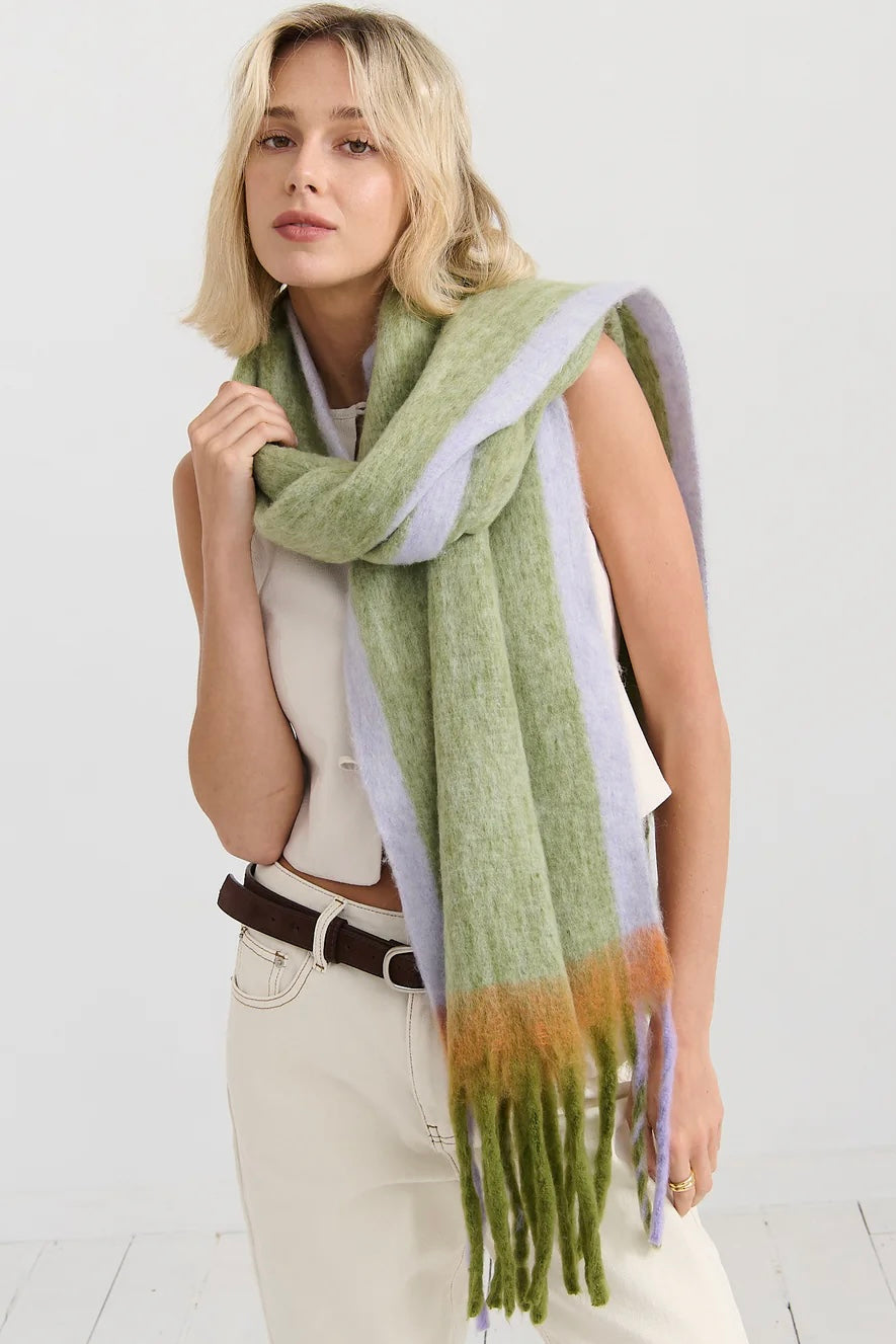 Woman in oversized green and lilac checkered scarf with fringe, wrapped in soft winter layers - Bohemian Love Runway scarf.