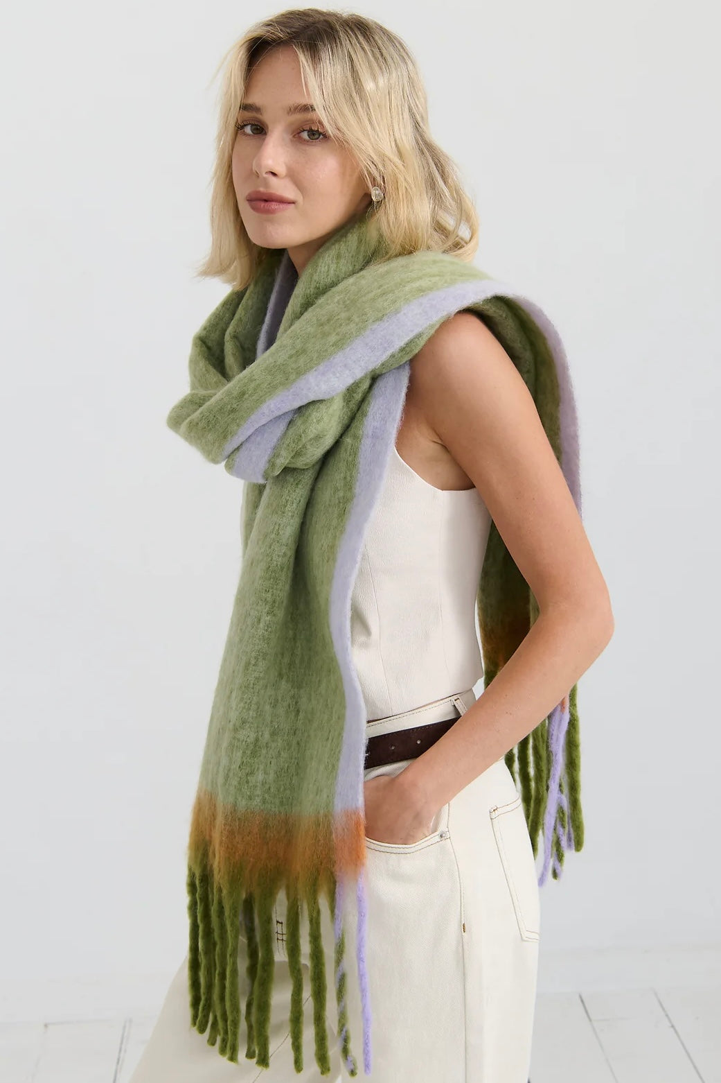 Woman in oversized green and lilac checkered scarf with fringe, wrapped in soft winter layers - Bohemian Love Runway scarf.