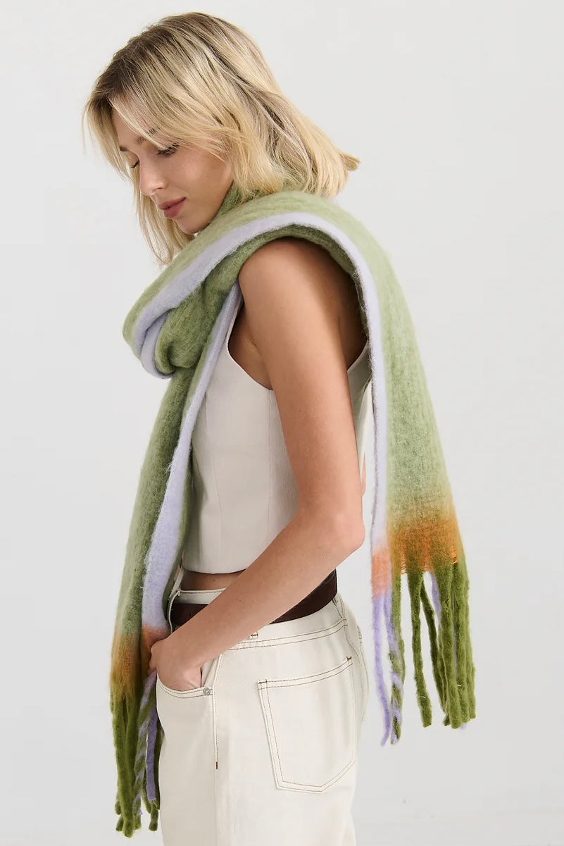 Woman in oversized green and lilac checkered scarf with fringe, wrapped in soft winter layers - Bohemian Love Runway scarf.