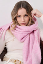 Woman in a soft blush pink boho scarf with tassels styled over a knit jumper - Rosabella scarf Australia.