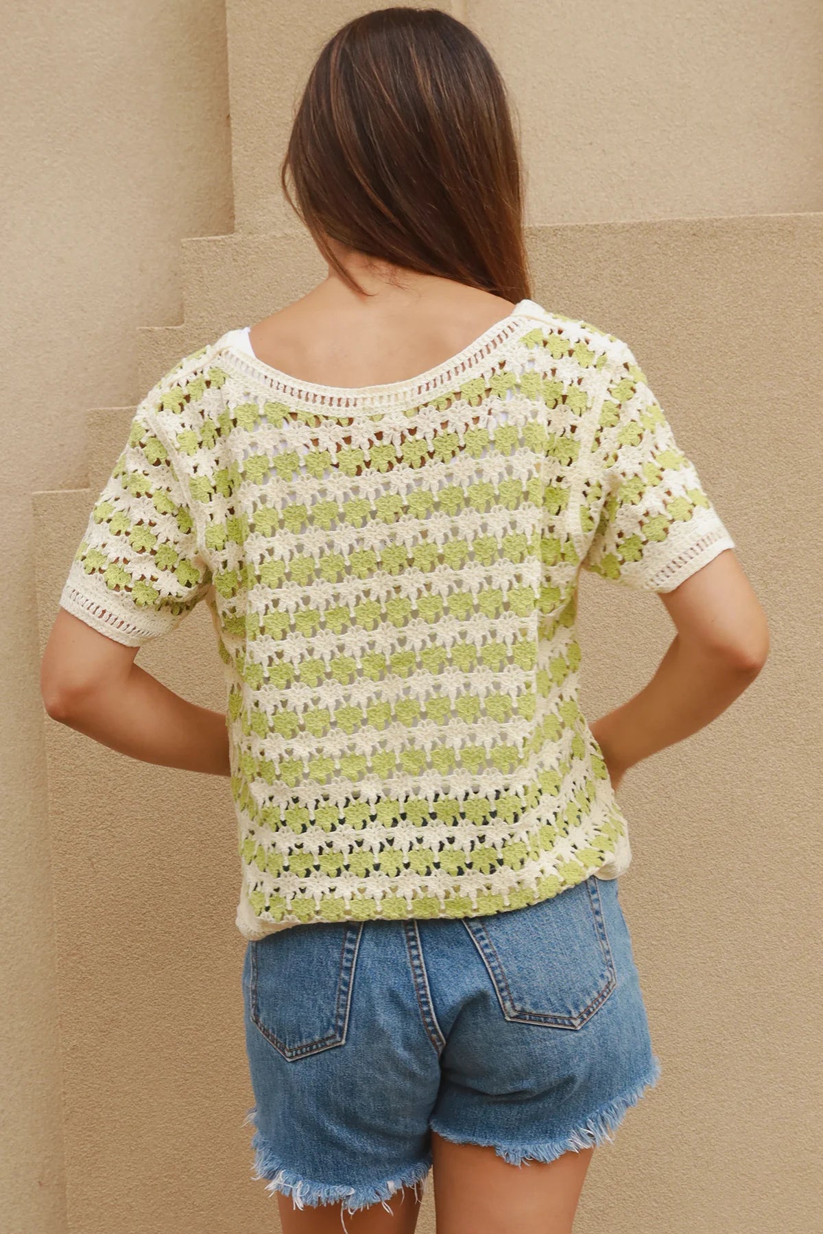 Woman wearing lime and cream crochet cotton top with vintage pattern and denim shorts - boho summer fashion Australia.