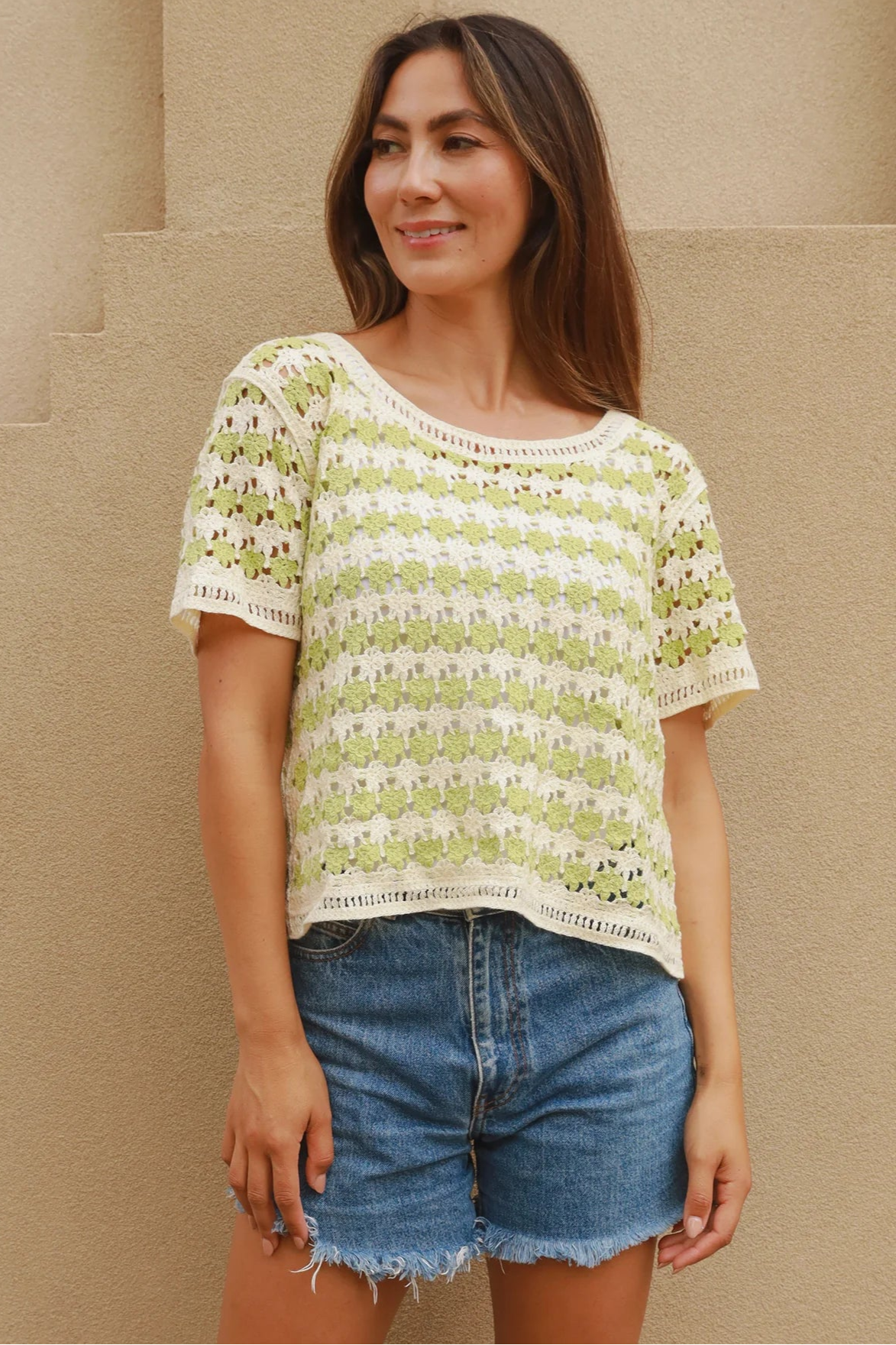 Woman wearing lime and cream crochet cotton top with vintage pattern and denim shorts - boho summer fashion Australia.
