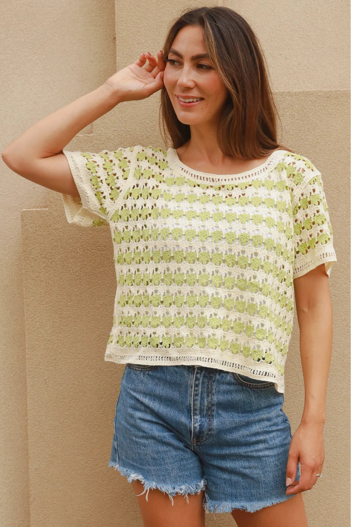 Woman wearing lime and cream crochet cotton top with vintage pattern and denim shorts - boho summer fashion Australia.