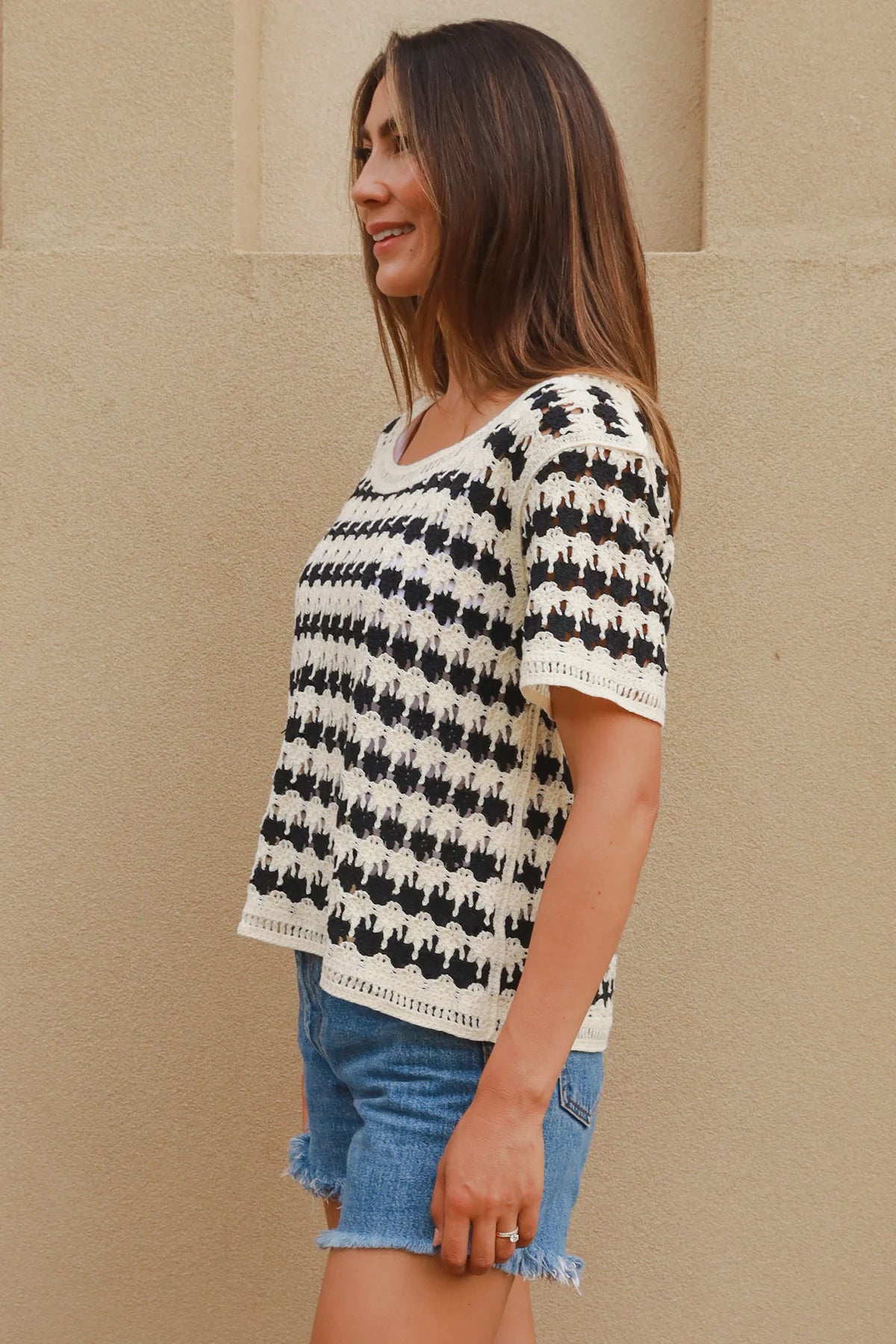 Woman wearing black and cream crochet cotton top with checkerboards pattern - boho summer fashion Australia.