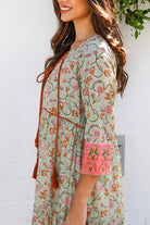 Lauren 100% cotton floral boho maxi dress in sage green with coral botanical print, tassel ties and contrast border hem