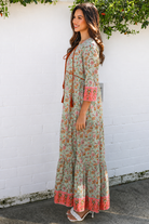 Lauren 100% cotton floral boho maxi dress in sage green with coral botanical print, tassel ties and contrast border hem
