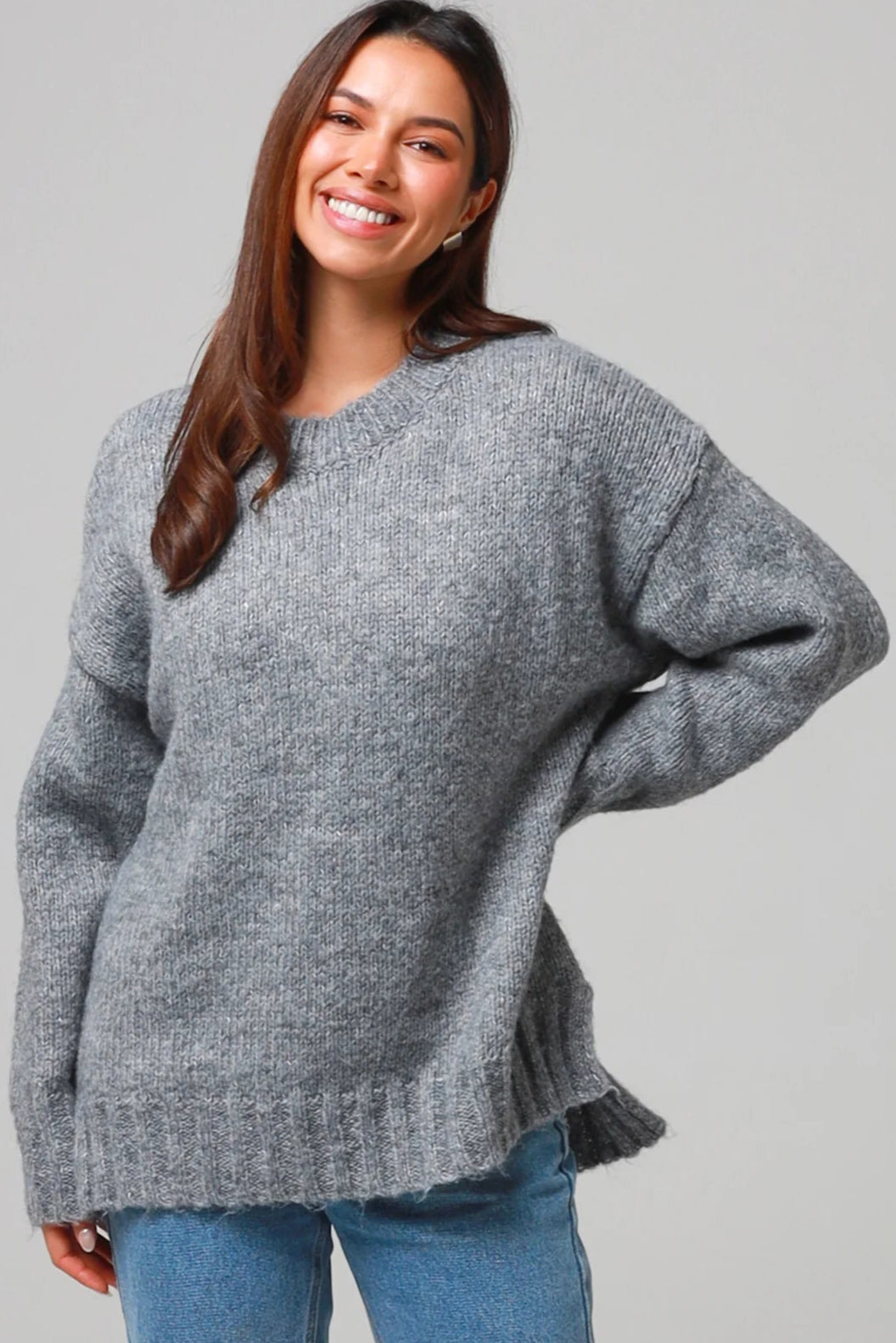 Woman wearing a grey wool blend knit jumper with ribbed cuffs and hem- boho winter jumper Australia.