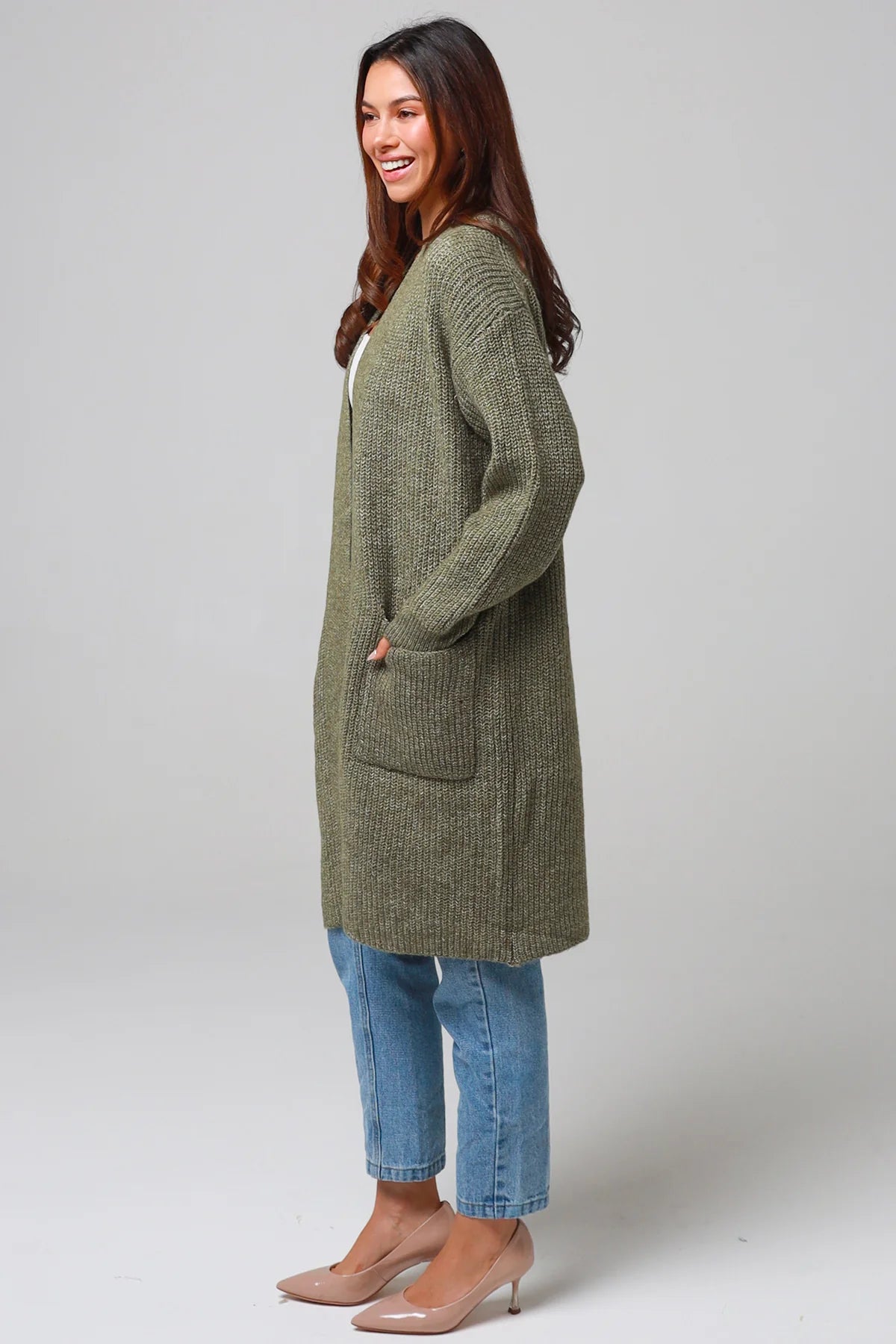 Woman in Khaki longline cardigan with patch pockets and denim - earthy boho wool blend knitwear Australia.
