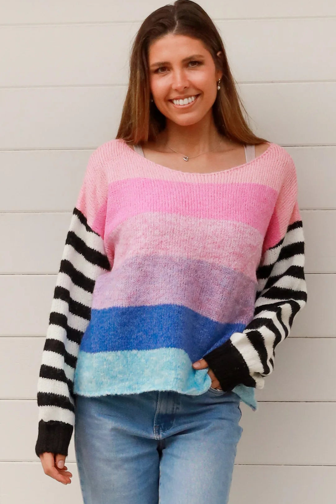 Woman wearing oversized pastel striped knit sweater with statement striped sleeves and relaxed winter boho styling in Australia
