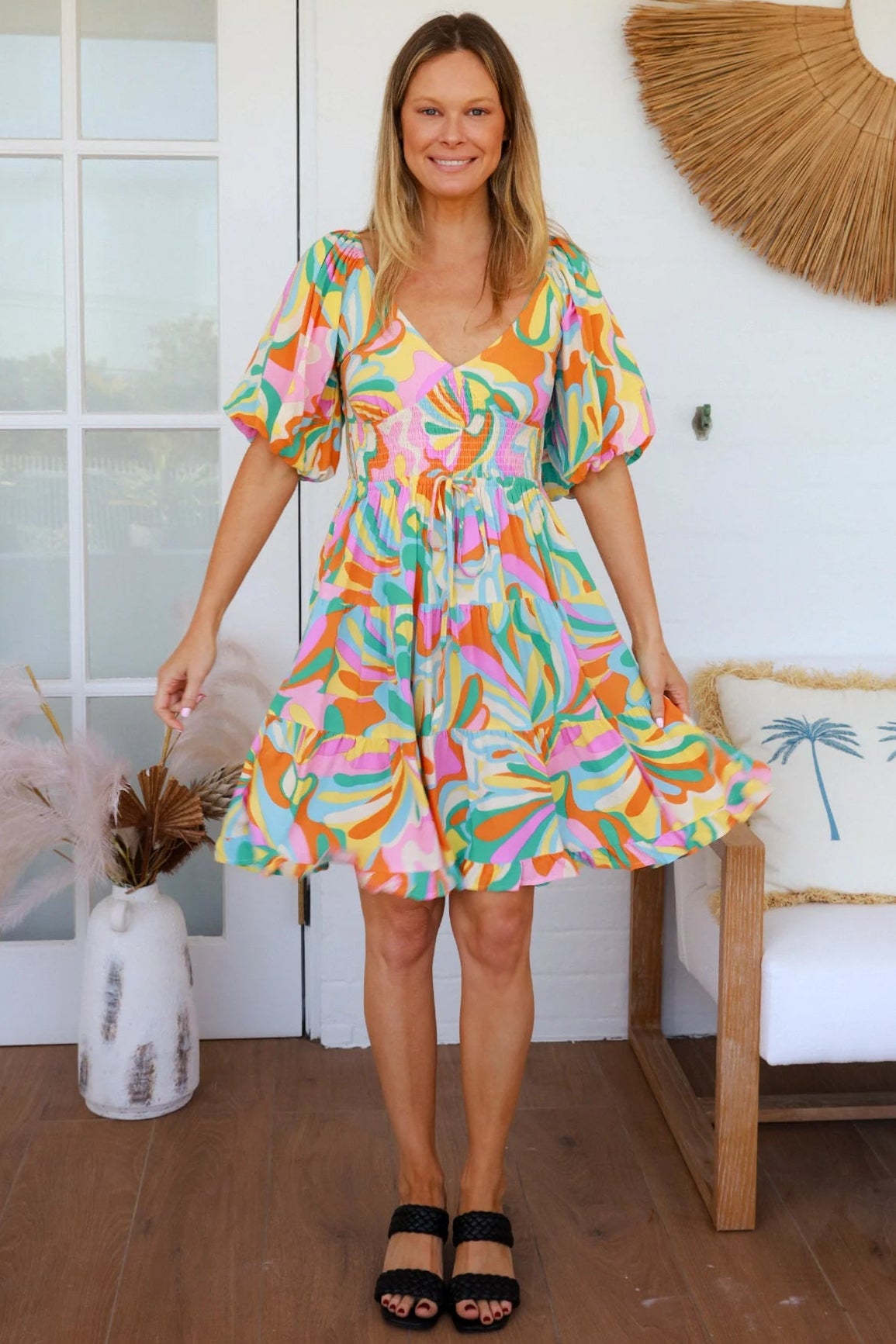 Woman in multicolour boho tiered mini dress with v-neckline, puff sleeves, shirred waist and oversized hemline - Australian bohemian style
