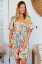 Woman in multicolour boho tiered mini dress with v-neckline, puff sleeves, shirred waist and oversized hemline - Australian bohemian style