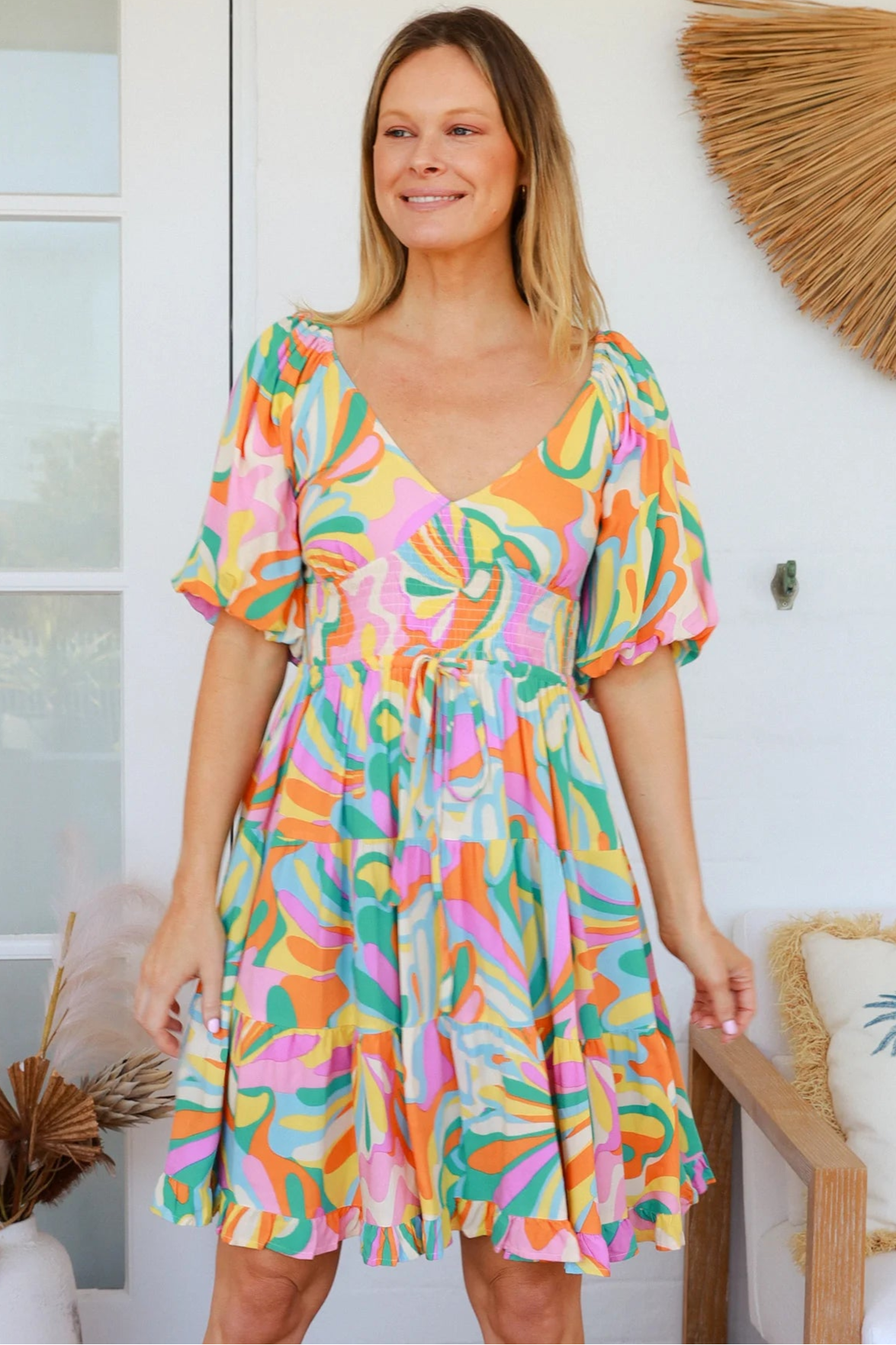 Woman in multicolour boho tiered mini dress with v-neckline, puff sleeves, shirred waist and oversized hemline - Australian bohemian style