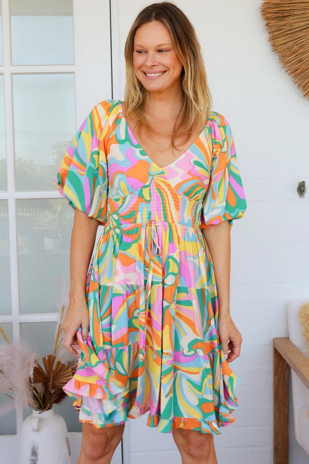 Woman in multicolour boho tiered mini dress with v-neckline, puff sleeves, shirred waist and oversized hemline - Australian bohemian style