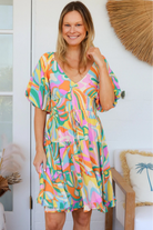 Woman in multicolour boho tiered mini dress with v-neckline, puff sleeves, shirred waist and oversized hemline - Australian bohemian style