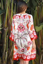 Woman wearing a ruby + blush floral boho mini dress with kimono sleeves + scalloped hem — Ruby Palm Dreamcatcher