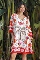 Woman wearing a ruby + blush floral boho mini dress with kimono sleeves + scalloped hem — Ruby Palm Dreamcatcher