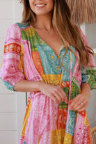 Woman in colourful patchwork paisley boho maxi dress with v-neck button bodice and tiered skirt - Boho Fashion Australia