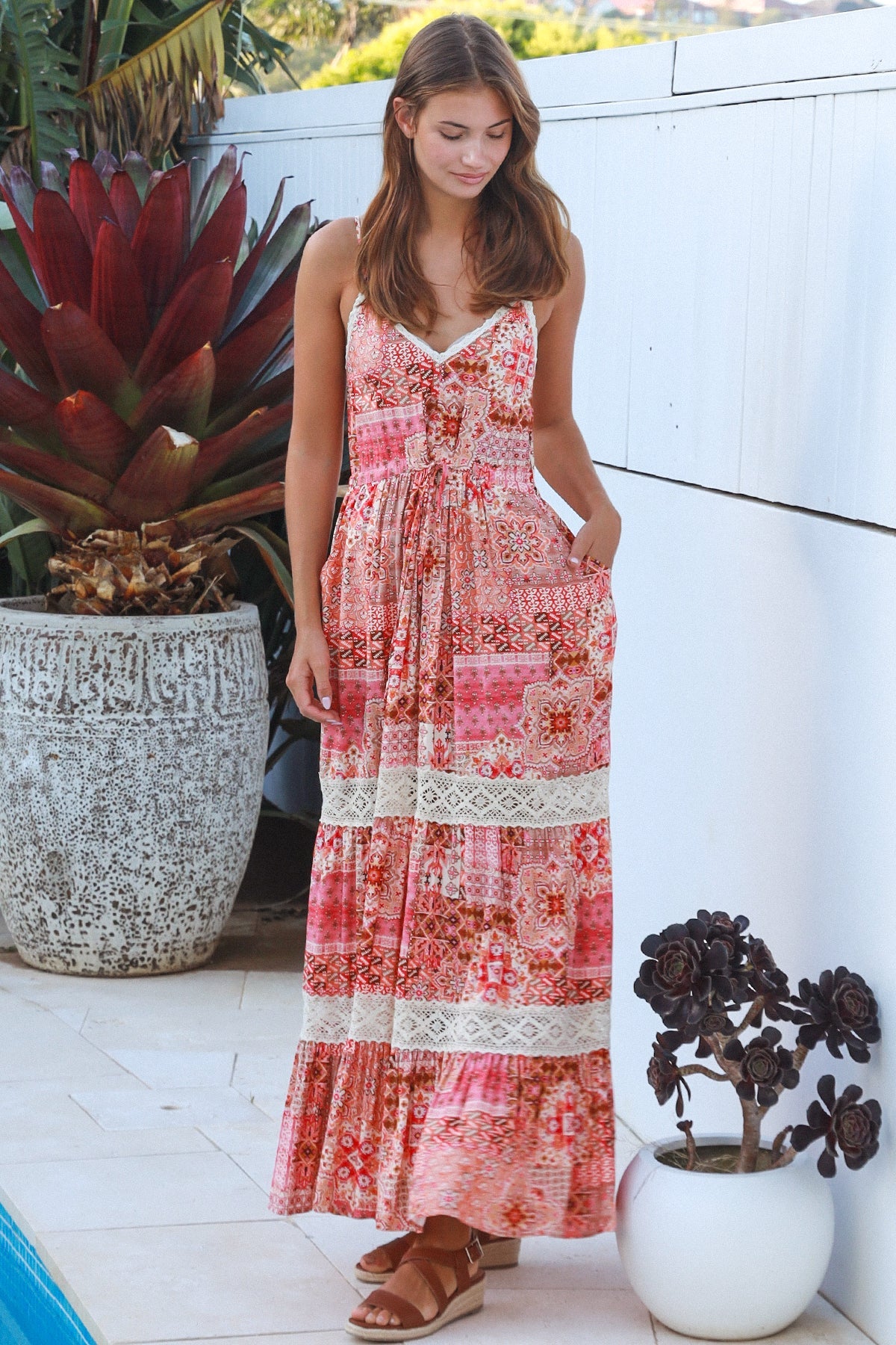 Woman wearing blush coral tiered rayon maxi dress with ivory lace, Dreamcatcher print, flowing summer boho style