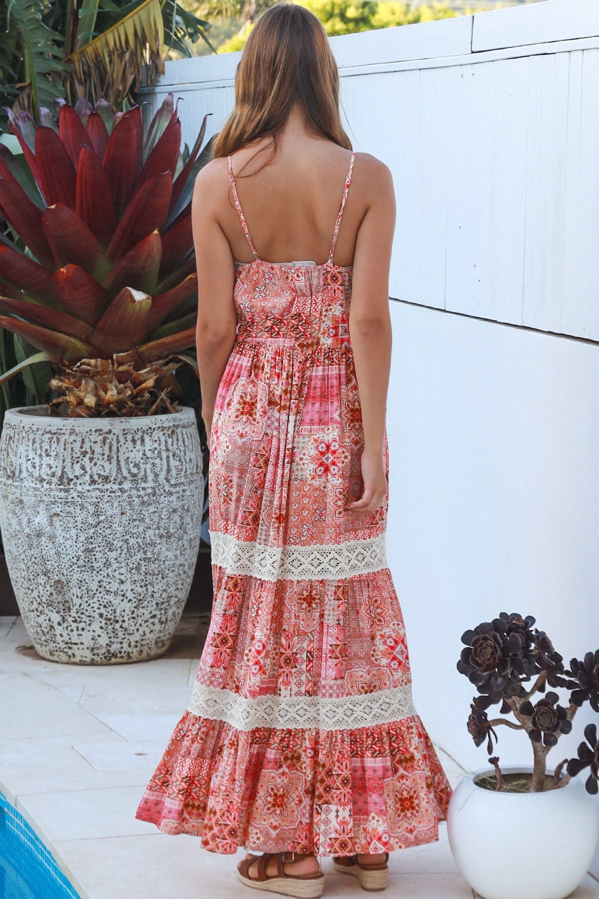 Woman wearing blush coral tiered rayon maxi dress with ivory lace, Dreamcatcher print, flowing summer boho style