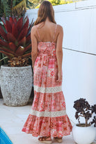 Woman wearing blush coral tiered rayon maxi dress with ivory lace, Dreamcatcher print, flowing summer boho style