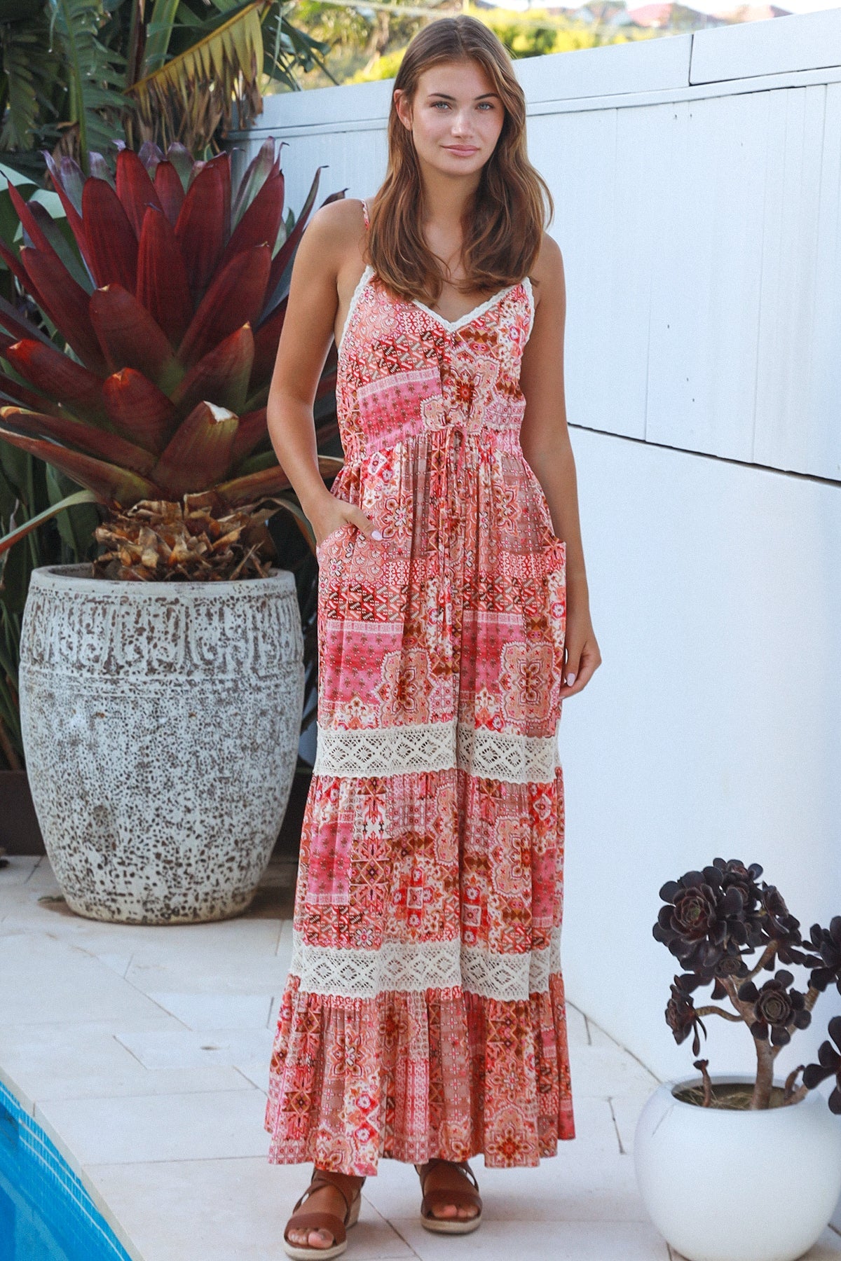 Woman wearing blush coral tiered rayon maxi dress with ivory lace, Dreamcatcher print, flowing summer boho style
