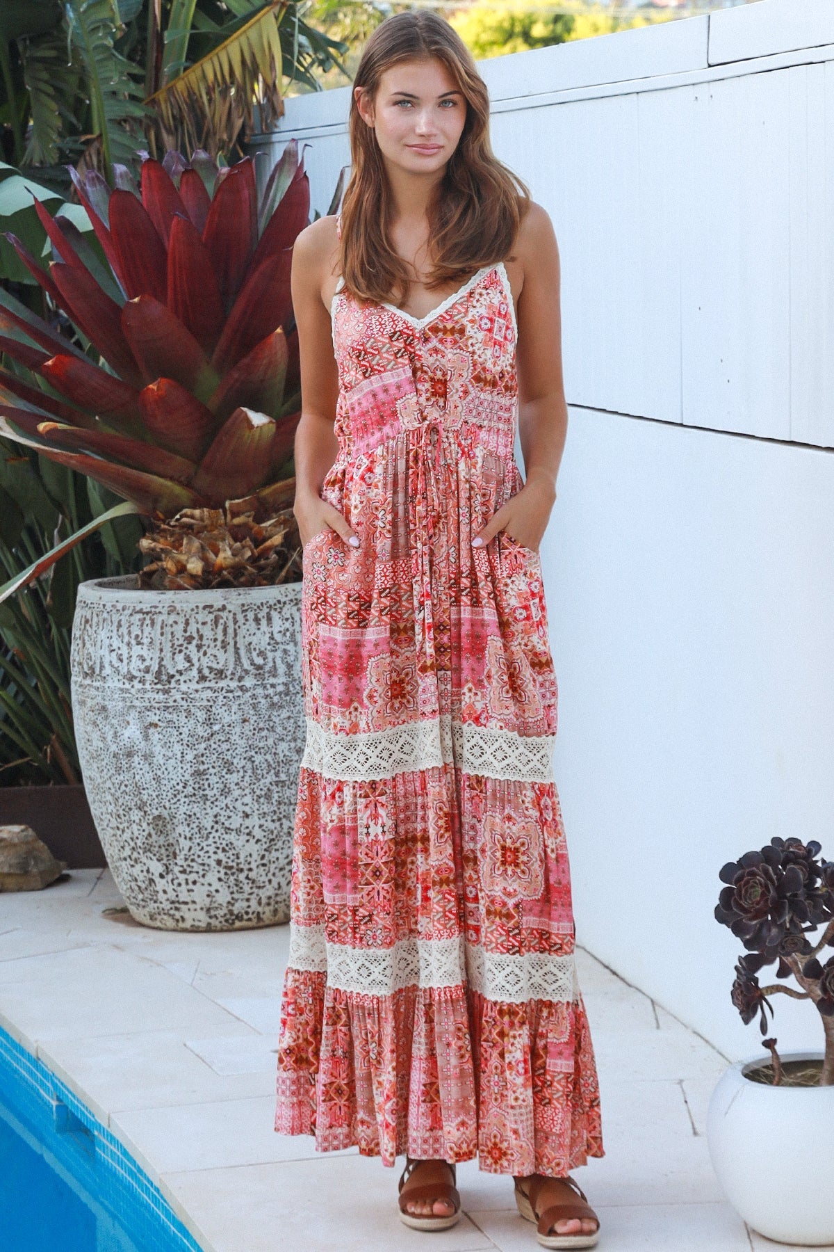 Woman wearing blush coral tiered rayon maxi dress with ivory lace, Dreamcatcher print, flowing summer boho style