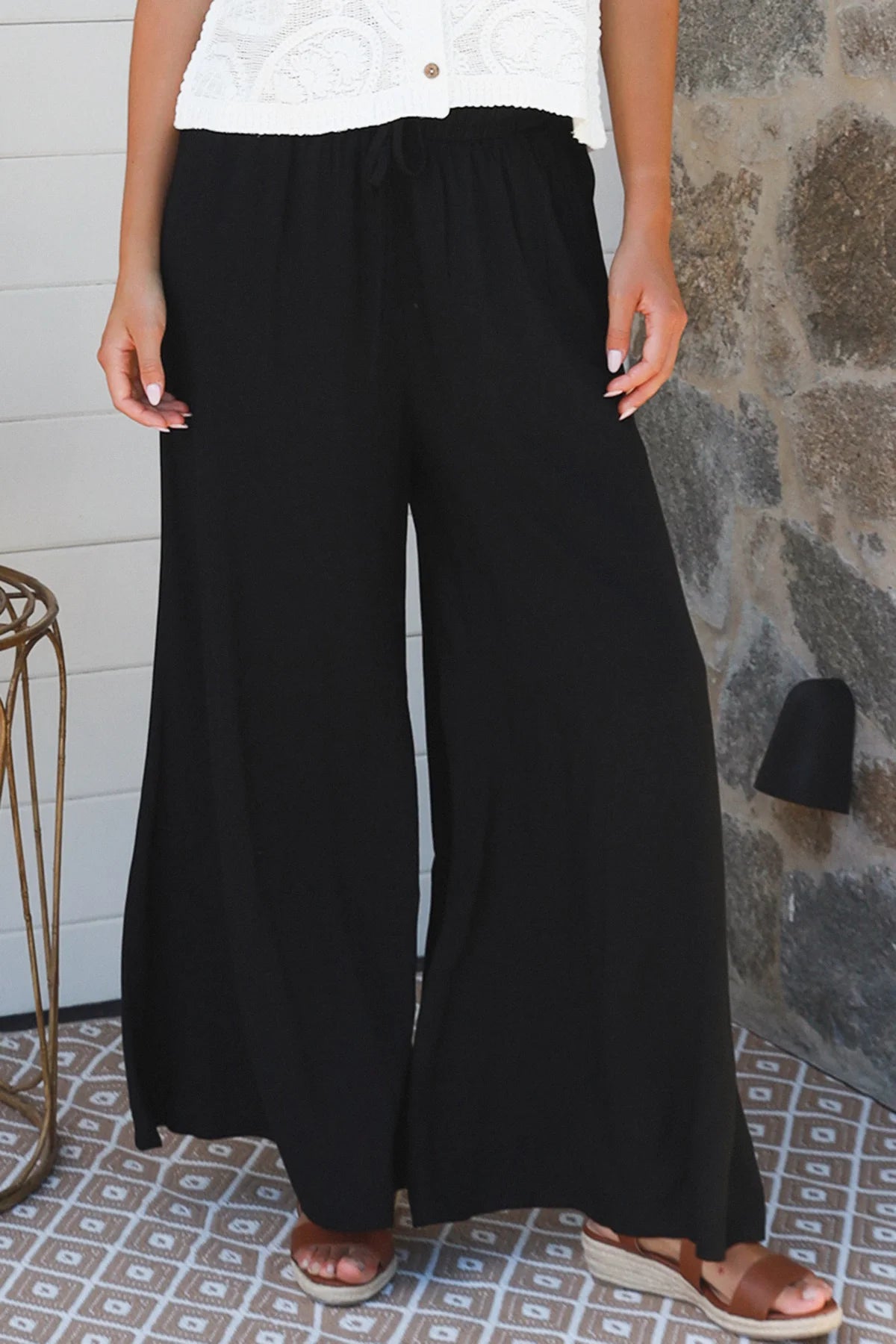 Black wide-leg rayon pants with elastic waist, front tie and side pockets